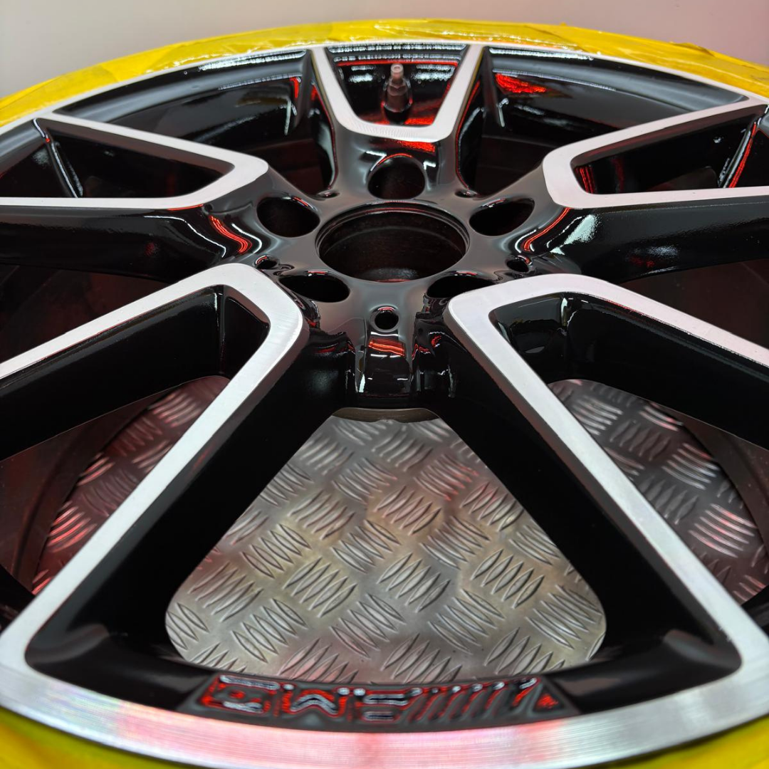 Close-up of freshly refinished AMG diamond cut alloy — gloss black and machined faces
